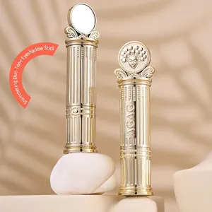 Dual-color shimmer eyeshadow stick with golden embossed casing and a classic relief design