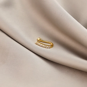 Close-up of a gold U-shaped non-piercing nose cuff with zircon heart and lightning details