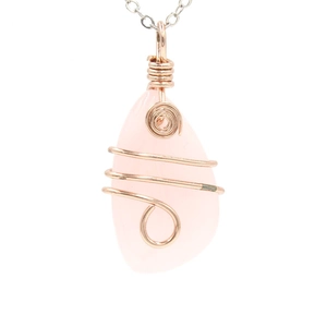 Detail of rose gold wire wrapped pink crystal pendant with fine silver chain necklace