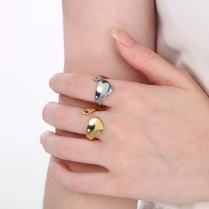 Detailed view of silver and gold irregular open rings on model fingers