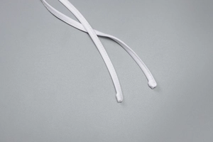 Détail des cordons blancs et des coutures sur une robe d'été en maille transparente