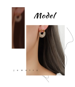 Détails de boucles d'oreilles de luxe en titane doré avec zircons sur un mannequin