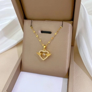 Elegant gold angel heart necklace with sparkling crystals in a beige jewelry box