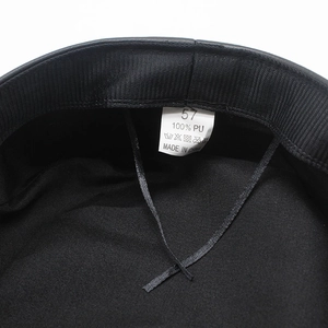Inside view of black PU leather baker boy hat showing size 57 label and fabric lining