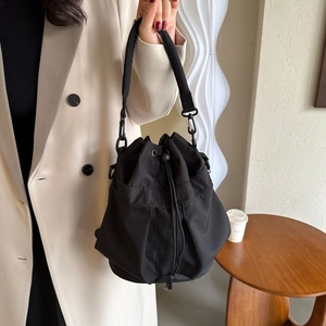 Détail du sac seau noir en nylon avec cordon de serrage et boucles métalliques