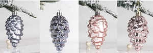 Detailed view of matte and glossy pine cone Christmas ornaments hanging on snowy branches