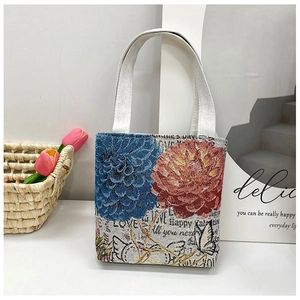 Close-up of floral embroidery on canvas tote bag with festive gold thread accents