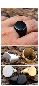 Polished stainless steel signet rings in black, gold, and silver finishes displayed on bark