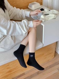 Detail of cotton socks showing cute bear embroidery and ribbed cuffs in various colors