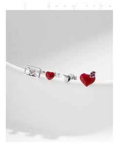 Detail view of 925 silver heart and envelope stud earrings set with sparkling stones