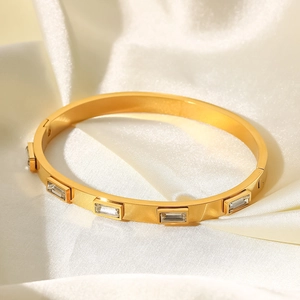 Détail d'un bracelet en acier doré 18K avec des pierres de zircone rectangulaires serties