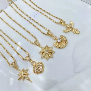 Golden octagonal star and heart pendant necklaces displayed on a white textured tray
