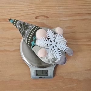 Detailansicht einer handgefertigten Weihnachtszwerg-Figur auf einer Waage mit 1632 Gramm