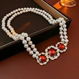 Detail of vintage double-layer pearl necklace with red crystal pendants and small diamonds