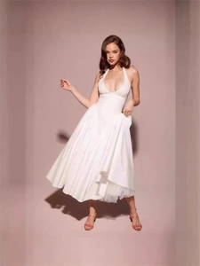 Elegant white halter neck dress with deep V-neck and pleated waist for a slim fit look