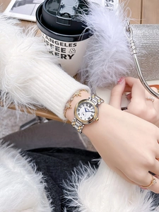 Gros plan d'une montre vintage pour femme avec bracelet en acier et chiffres romains au poignet