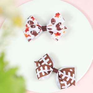 Rugby themed hair bows with maple leaf patterns for girls on a decorative plate