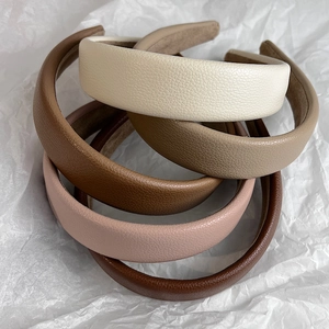 Chic padded litchi pattern leather headbands in earthy tones on a white background