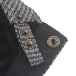 Macro shot of houndstooth wool tweed texture with bronze adjustable metal buckle