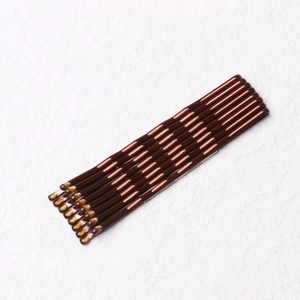Close-up of ten brown glossy bobby pins neatly arranged on a white textured background