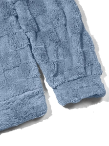 Close-up of blue fleece hoodie detail showing plush checkerboard texture and elastic cuffs