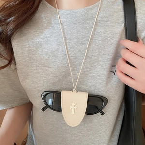 Close-up of beige leather magnetic glasses holder necklace with cross pendant detail