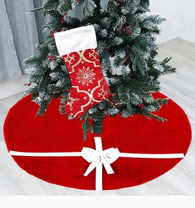 Close-up of red plush Christmas tree skirt featuring a decorative large white ribbon bow