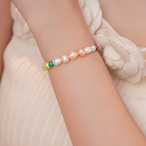Gros plan d'un bracelet en perles baroques françaises avec fermoir magnétique au poignet