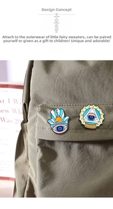 Close-up of Hamsa Hand and Eye of Providence enamel pins on a green canvas backpack