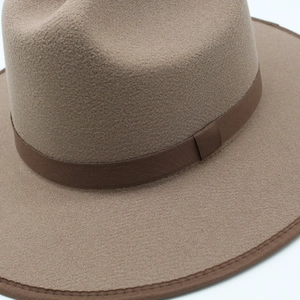 Detail of wool felt fedora hat showing khaki texture and dark brown ribbon band