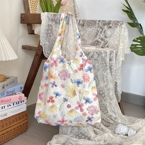 Detail of floral chiffon tote bag with watercolor tulips hanging on a vintage wooden chair