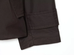 Detailed close-up of dark brown waterproof parka sleeve with twill texture and stitching