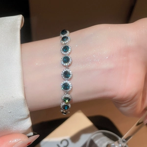 Détail d'un bracelet halo avec des pierres rondes bleu foncé et des zircons blancs brillants