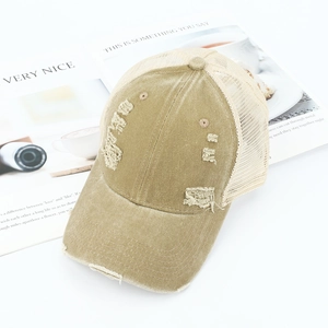 Detailopname van de retro gewassen kaki trucker pet met distressed gaten en mesh