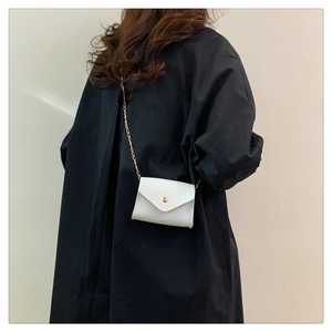 Detailed view of white crocodile texture crossbody bag with gold chain and metal clasp