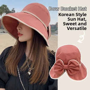 Detail of a sun hat featuring a large decorative bow and elegant contrast trim