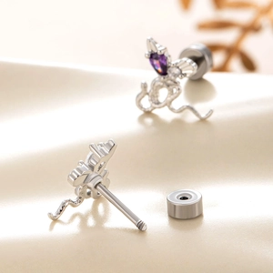 Orecchini a serpente in argento con cristalli viola a cuore su sfondo beige