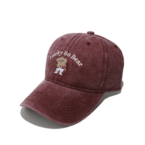 Close-up of cute cartoon bear embroidery and texture on burgundy washed cotton cap