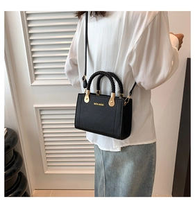 Vue arrière d'un mannequin portant un petit sac cabas noir avec une poignée tressée chic