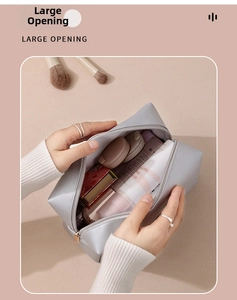Detail showing large opening of silver PU leather makeup bag with spacious interior capacity