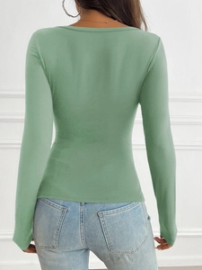 Detail view of the slim fit green long sleeve shirt from behind paired with jeans