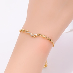 Detail of elegant gold bracelet featuring a V-shaped diamond pendant on a minimalist chain
