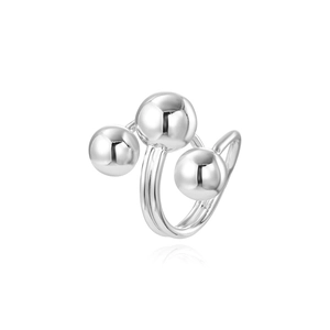 Detailed view of silver layered open ring with three polished metal spheres on white background