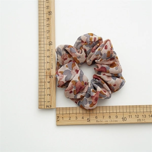 Floral print scrunchie with cream base and colorful abstract pattern, 10.5cm diameter