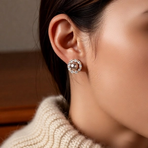 Close-up of elegant 14k gold plated grey pearl earring with sparkling crystals on ear