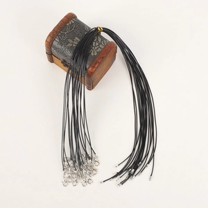 Macro detail of black leather necklace cords bundle with metal lobster clasps and chains