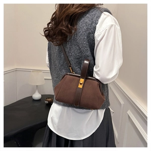 Detailed back view of a vintage brown shell bag with golden lock and leather handles