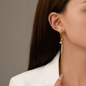 Elegant gold butterfly tassel earrings shown on model with long metallic fringe drops