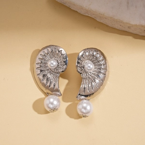 Elegant conch texture silver needle earrings with pearl pendants on a textured stone base