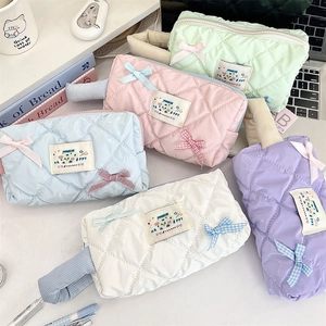 Detail showing colorful macaron aesthetic quilted cosmetic bags with cute bows and handles